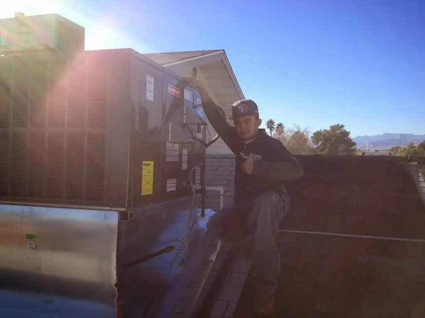 HVAC technician performing Air Duct Repair on a rooftop unit in Augusta